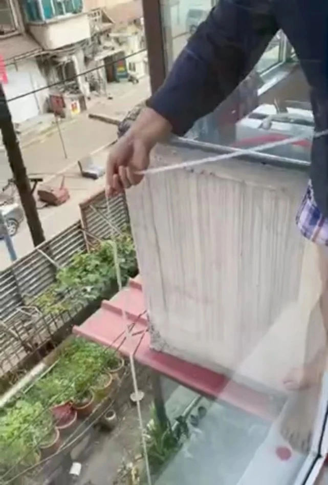 狗狗因疫情被困家中饿趴，楼上大哥自制吊索隔空投喂
